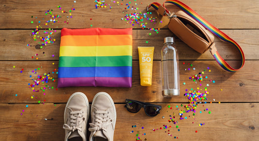 Pride parade preparation essentials flat lay with rainbow flag, sunscreen, water bottle, and comfortable shoes