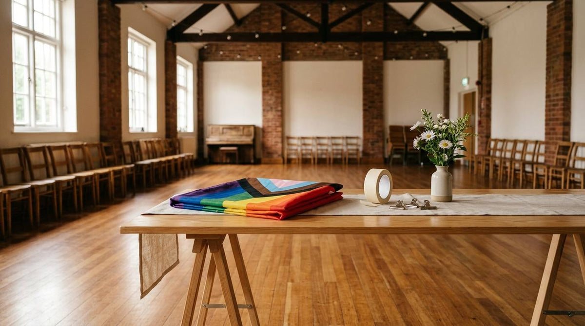 Folded Progress Pride flag on a welcome table in an empty community hall